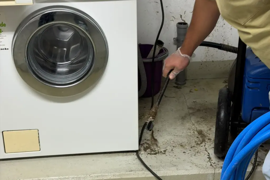 Rohrreinigung in Karlsruhe: Monteur von BT-Haustechnik reinigt Abflussleitung mit Spülschlauch